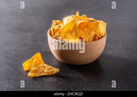 Nachos in Holzschale auf schwarzem Schieferhintergrund Stockfoto