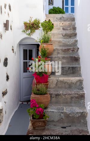 Keramik-Blumentöpfe auf steilen Steintreppen in Imergovigli, Santorini, Griechenland Stockfoto