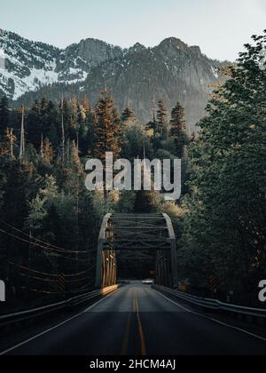 Vertikale Aufnahme einer langen Straße durch ländliche Berggebiete in Washington Stockfoto