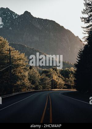 Vertikale Aufnahme einer langen Straße durch ländliche Berggebiete in Washington Stockfoto