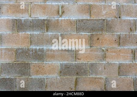 Ausschnitt einer verwitterten roten und grauen Breeze Block Wand wurde eingetaucht Stockfoto