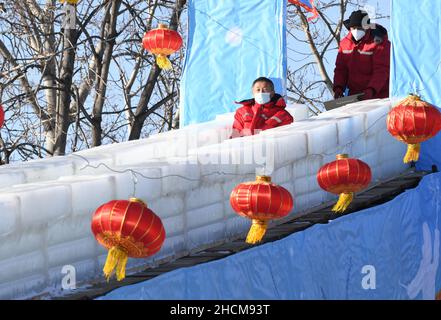 Peking, China. 30th Dez 2021. Mitarbeiter testen eine Eisrutsche im Yuanmingyuan Park in Peking, der Hauptstadt Chinas, 30. Dezember 2021. Der Alte Sommerpalast, Yuanmingyuan, kündigte am Donnerstag an, dass er ein Eis- und Schneefest veranstalten wird, das um den Neujahrstag 2022 eröffnet wird und bis Februar dauert, um die Olympischen Winterspiele 2022 in Peking zu begrüßen. Quelle: Luo Xiaoguang/Xinhua/Alamy Live News Stockfoto