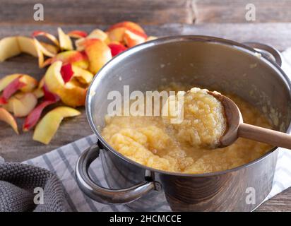 Hausgemachter Apfelmus in einem Topf mit Holzlöffel Stockfoto