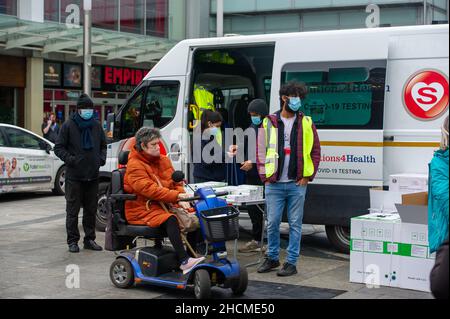 Slough, berkshire, Großbritannien. 30th. Dezember 2021. NHS Test and Trace und Solutions4Health gaben heute im Stadtzentrum von Slough kostenlose Covid-19 Lateral Flow Self Testing Kits in Boxen mit 7 oder 20 Tests heraus. Angesichts des weit verbreiteten Mangels an Covid-19 Lateral Flow-Tests nahmen einige Leute Beutel voller der 20 Multi-Pack-Testkits mit. Die Rapid Covid-19 (Antigen) Selbsttestpakete des Orient Gene wurden als nicht für den Weiterverkauf gekennzeichnet. Quelle: Maureen McLean/Alamy Live News Stockfoto