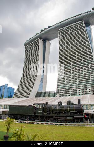 Die 158 Jahre alte Original Orient Express Lokomotive in Garden by the Bay Singapore. Der Hintergrund ist das Marina Bay Sand Hotel. Stockfoto