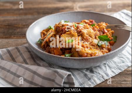 Vegetarisches Nudelgericht mit Tortellini, gefüllt mit Käse und gekocht in einer köstlichen Gemüsestomatensauce. Serviert mit Parmesankäse Stockfoto