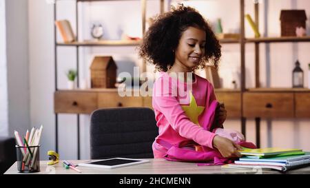 Happy african american Kind Verpackung Notebooks im Rucksack Stockfoto