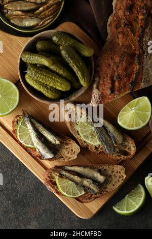 Brett mit Sandwiches mit Sprossen auf strukturiertem Hintergrund Stockfoto