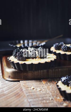 Frisch gebackene Brombeeren- und Vanillepudding-Torten. Stockfoto