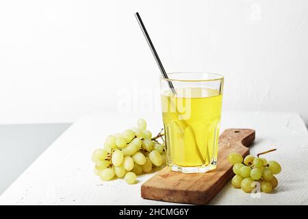 Ein Glas Traubensaft und ein paar weiße Trauben. Stockfoto