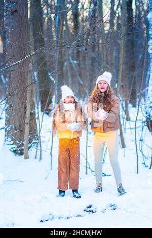 Zwei Mädchen im Teenageralter, die Spaß beim Spielen mit Schnee haben. Schnee-Spiele. Winterurlaub. Stockfoto