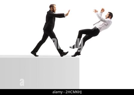 Ganzkörperaufnahme eines Geschäftsmannes, der einen Mann aus einer auf weißem Hintergrund isolierten Wand schiebt Stockfoto