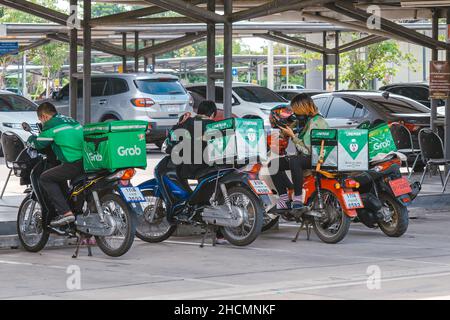 KANCHANABURI, THAILAND-AUGUST 22,2021 : Gruppe von Lineman und Grab Fahrer parken Motorrad zu entspannen und warten, um Essen aus dem Restaurant am Parkplatz l zu bekommen Stockfoto