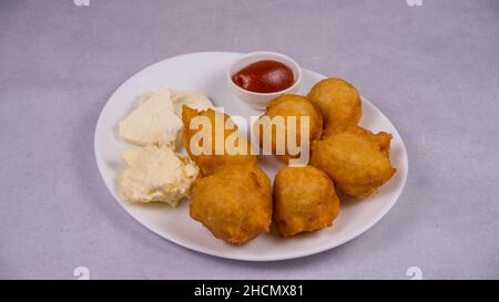 Nahaufnahme von Fleischbällchen mit Käse und Ketchup auf einem weißen Teller Stockfoto