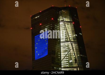 30. Dezember 2021, Hessen, Frankfurt/Main: Bei einem Testlauf wird die europäische Flagge auf die Südfassade des Hauptquartiers der Europäischen Zentralbank (EZB) im Frankfurter Ostende projiziert. Vor 20 Jahren wurde am Silvesterabend in zwölf EU-Ländern die einheitliche europäische Währung, der Euro, eingeführt. Für Deutschland bedeutete dies, Auf Wiedersehen zur D-Mark zu sagen. Vom 31. Dezember 2021 bis zum 9. Januar 2022 wird die Fassade der EZB in den Abendstunden beleuchtet. Foto: Arne Dedert/dpa Stockfoto