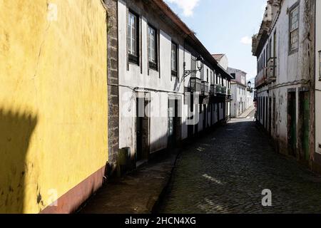 Traditionelle schwarz-weiße Häuser in engen gepflasterten Straßen in der Stadt Horta, Faial, Azoren, Portugal Stockfoto