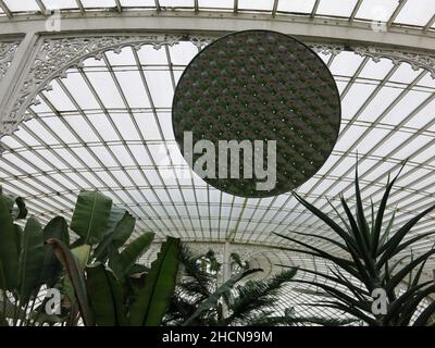 An der Glasdecke im Gewächshaus des Kibble Palace in den Glasgow Botanic Gardens hängt ein runder, facettierter Spiegel. Stockfoto