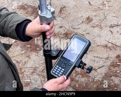 Techniker und Vermesser überprüfen das GPS-System und die gesamten Stationsdaten mithilfe der GPS-Anwendung. Stockfoto