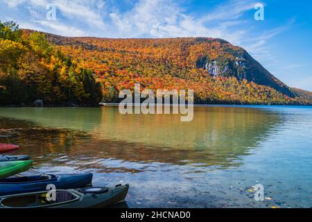 Kajaks Reihen sich an einem Vermont Herbstnachmittag am Ufer des Lake Willoughby an Stockfoto