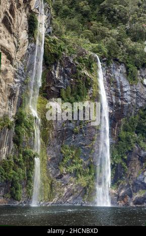 Wasserfall, der den Berghang hinunter in Milford Sound, Teil des Fiordland National Park, South Island, New Zeland, stürzt Stockfoto