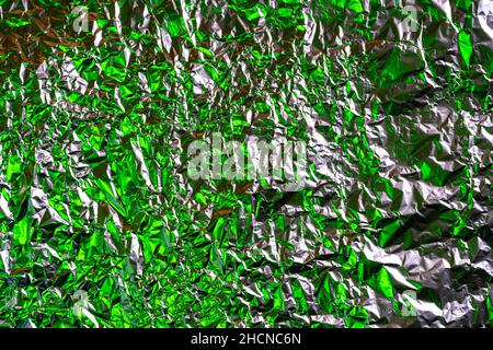 Zerknitterte Folie Hintergrund mit farbigen Lichtern beleuchtet Stockfoto