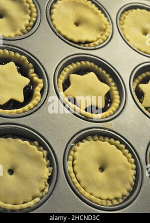 Hausgemachte, tiefgefüllte Hackfleisch-Pasteten, die bereit sind, im Tablett gebacken zu werden Stockfoto