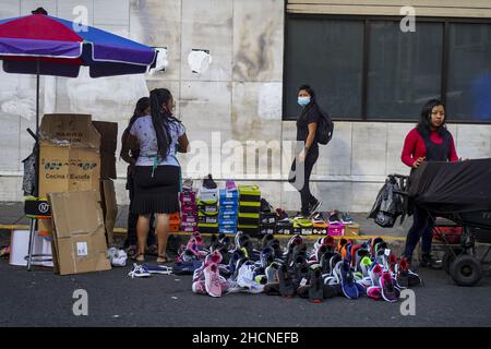 San Salvador, El Salvador. 30th Dez 2021. Schuhe werden auf dem Straßenmarkt ausgestellt, wenn die Leute einen Silvesterabend in der Innenstadt einkaufen. Kredit: SOPA Images Limited/Alamy Live Nachrichten Stockfoto