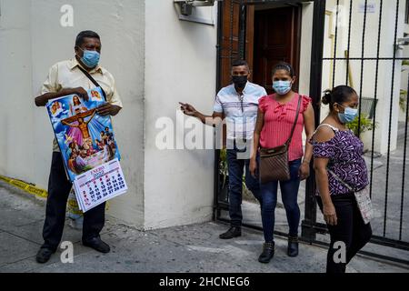San Salvador, El Salvador. 30th Dez 2021. Ein Mann verkauft 2022 Kalender außerhalb der Kathedrale von San Salvador, während die Leute in der Innenstadt für den Silvesterabend einkaufen. Kredit: SOPA Images Limited/Alamy Live Nachrichten Stockfoto