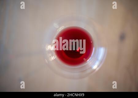Draufsicht auf den Rotwein im Glas auf dem Holztisch Stockfoto