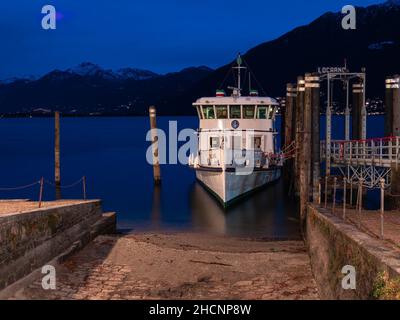 Locarno, Schweiz - 29. Dezember 2021: Das Schiff Milano, das zur blauen Stunde in der Marina von Locarno am Lago Maggiore festgemacht wurde Stockfoto
