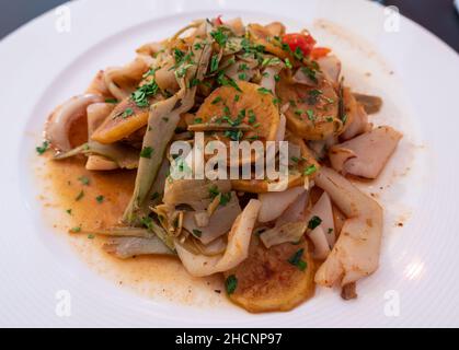 Ein typisches mediterranes Gericht - Calamari mit Artischocken und Gemüse Stockfoto