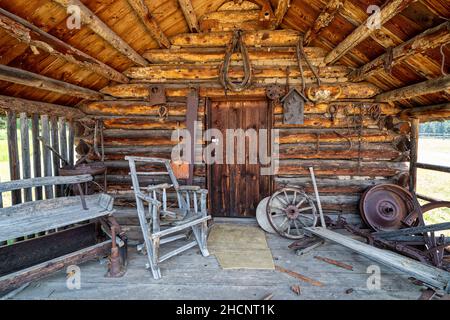 Veranda und Vordereingang zu einer rustikalen Blockhütte Stockfoto