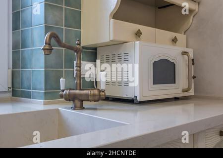 Seife und Shampoo Spender in der Nähe von Keramik Wasserhahn Waschbecken mit Wasserhahn in der teuren Küche Stockfoto