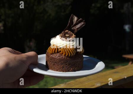 Individueller Marquise-Kuchen auf einem Teller. Dessert wird in einem Café im Freien serviert Stockfoto