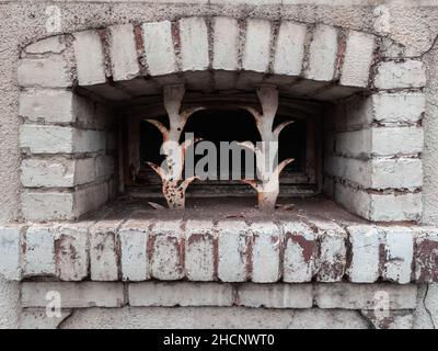 Kellerfenster mit Metallstangen auf einem antiken Haus in der Normandie, Frankreich Stockfoto
