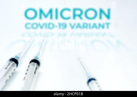 Omicron Covid-19 Variante verschwommener Text über zwei Spritzen isoliert auf weißem Hintergrund. Covid-19 Coronavirus-Mutation. Prävention und Impfstoff Stockfoto