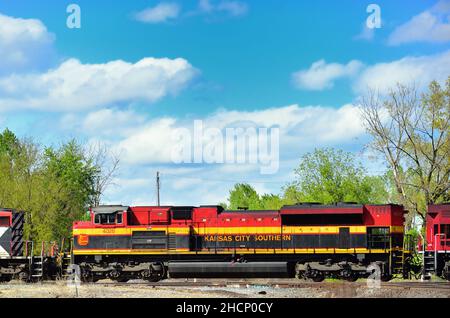 Elgin, Illinois, USA. Drei Lokomotiven, darunter eine Kansas City Southern Railway Einheit, führen einen Güterzug westwärts durch Spaulding Junction. Stockfoto