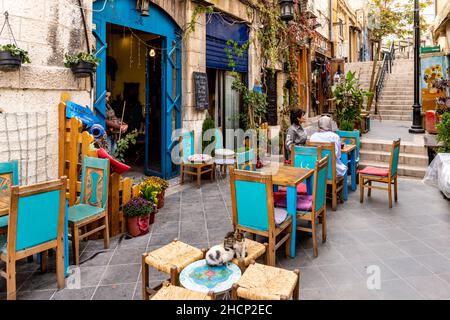 Drei Kätzchen, die vor Einem Café in der Innenstadt von Amman, Amman, Jordanien, sitzen. Stockfoto