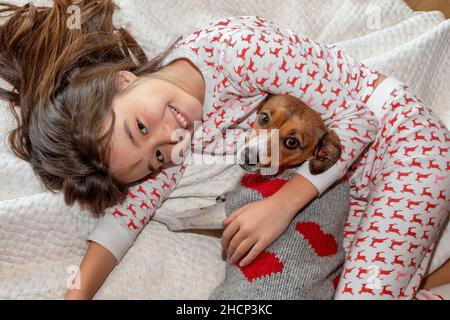 Ein 9-jähriges Mädchen mit ihrem Haustier auf ihrem Bett Stockfoto