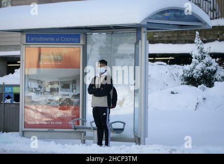 Vancouver, Kanada. 30th Dez 2021. Nach einem nächtlichen Schneefall in Richmond, British Columbia, Kanada, wartet am 30. Dezember 2021 ein Bewohner an einer Bushaltestelle. Starker Schneefall hat die Region Metro Vancouver am Donnerstag überschüttet. Quelle: Liang Sen/Xinhua/Alamy Live News Stockfoto