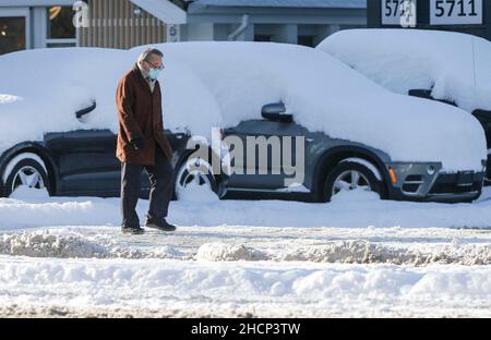 Vancouver, Kanada. 30th Dez 2021. Ein Bewohner spaziert nach einem nächtlichen Schneefall in Richmond, British Columbia, Kanada, am 30. Dezember 2021 auf einer Straße. Starker Schneefall hat die Region Metro Vancouver am Donnerstag überschüttet. Quelle: Liang Sen/Xinhua/Alamy Live News Stockfoto