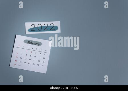 Weißer Kalender für Februar 2022 auf grauem Hintergrund. Neujahrskonzept Stockfoto