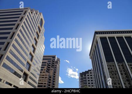 Hohe Geschäftsgebäude werden tagsüber von der Straße aus gesehen. Stockfoto