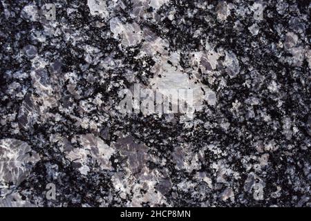 Schöner gemusterter schwarzer Granitstein mit schwarz-weiß-grauen grobkörnigen Mustern. Marmor Finish Stein schwarzen Marmor Fliesen für Stockfoto