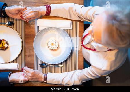 Zwei Senioren halten sich bei ihrem romantischen Date die Hände Stockfoto