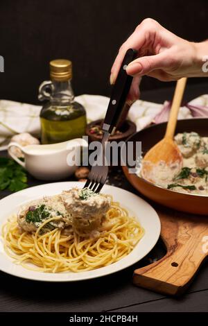 Portion leckere Fleischbällchen mit Spinat in einer cremigen Sauce Stockfoto