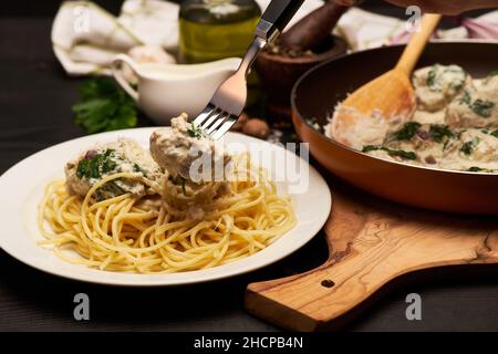 Portion leckere Fleischbällchen mit Spinat in einer cremigen Sauce Stockfoto