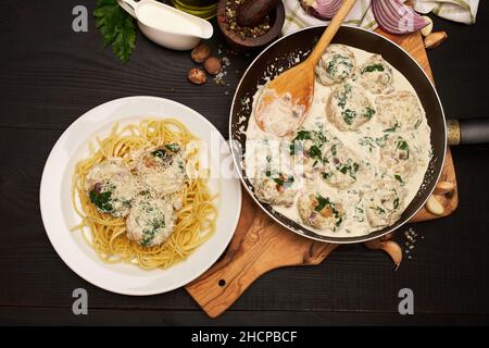 Portion leckere Fleischbällchen mit Spinat in einer cremigen Sauce Stockfoto