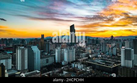 KUNMING, CHINA - 30. DEZEMBER 2021 - Luftfoto vom 30. Dezember 2021 zeigt eine spektakuläre Stadtlandschaft bei Sonnenuntergang in Kunming, Provinz Yunnan, China. Stockfoto