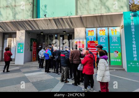 SHANGHAI, CHINA - 31. DEZEMBER 2021 - die Menschen warten in einer langen Schlange auf die COVID-19 Booster Needle am 31. Dezember 2021 in Shanghai, China. Stockfoto